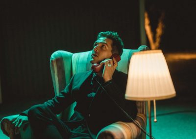 Chris Emray - Aufnahme aus Musikvideo Sleepwalking - Chris sitzt in Ohrensessel und telefoniert