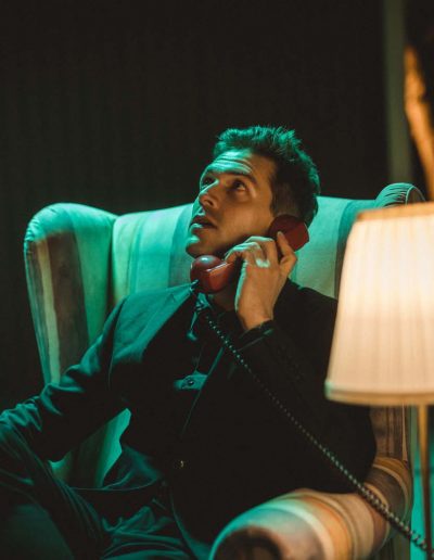 Chris Emray - Aufnahme aus Musikvideo Sleepwalking - Chris sitzt in Ohrensessel und telefoniert